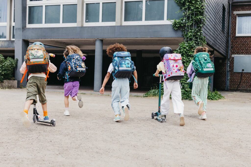 Schulkinder mit Schulranzen auf dem Weg in die Schule
